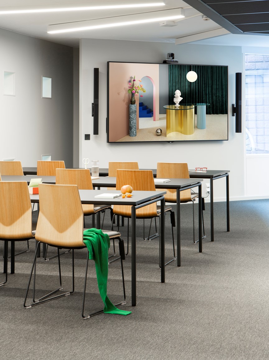 Møterommet Kristiania med stoler på rekke med TV skjerm i bakgrunnen og et grønt sjal hengende på en stol