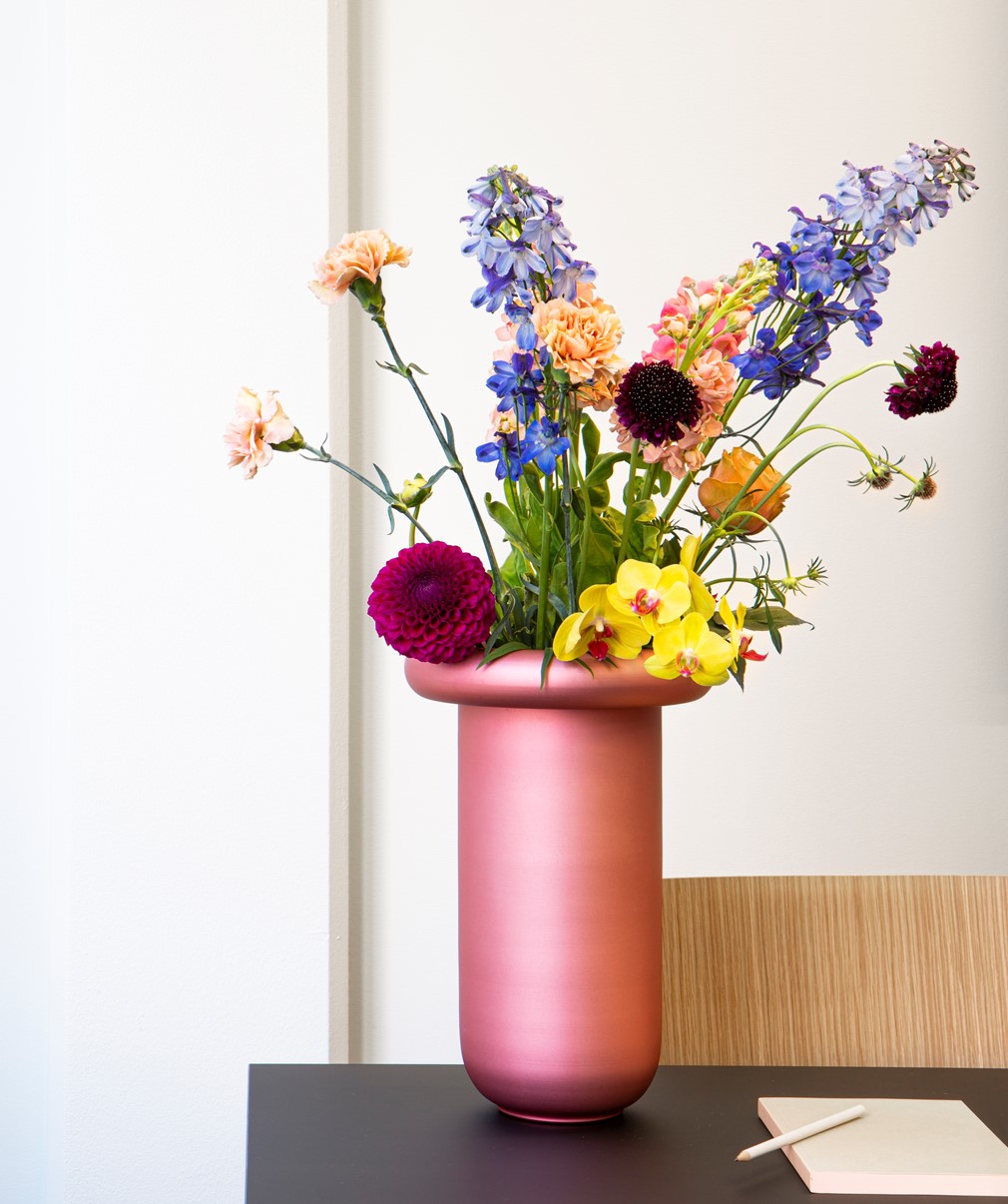 Rosa blomstervase med fargerike blomster