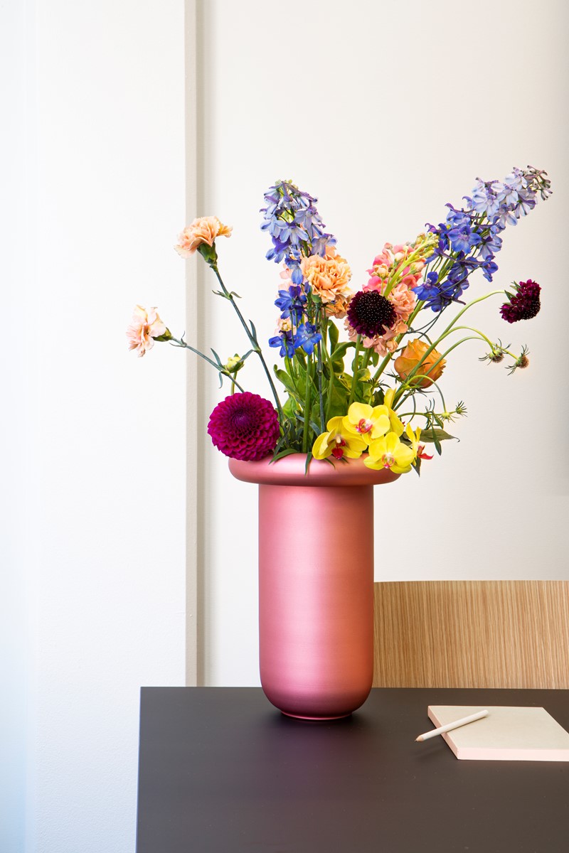 Rosa blomstervase med fargerike blomster